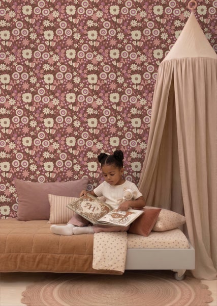 Vliestapete mit floralem Retro-Muster im Kinderzimmer, Mädchen liest ein Buch auf einem Bett mit Baldachin.