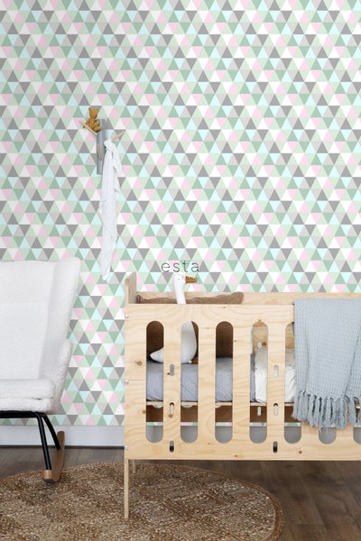 Kinderzimmer mit geometrischer Tapete, Gitterbett und Schaukelstuhl