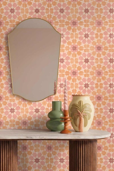 Wandgestaltung mit Mustertapete in geometrischem Stern-Design. Davor steht ein Konsolentisch mit Marmorplatte, dekoriert mit Vasen und einem Spiegel.