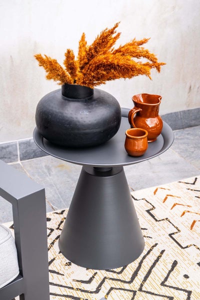 Moderner runder Beistelltisch aus Metall in Anthrazit mit konischem Standfuß, dekoriert mit Vase, Trockengras und Terrakotta-Gefäßen.