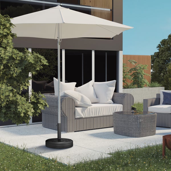 Moderner Sonnenschirm mit Schirmständer auf einer Terrasse mit Gartenmöbeln aus grauem Geflecht und hellen Kissen.