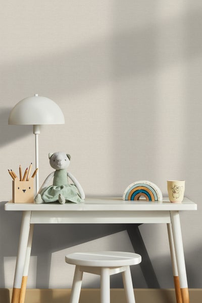 Heller Kinderzimmerbereich mit Schreibtisch und Stuhl vor einer strukturierten Tapete.