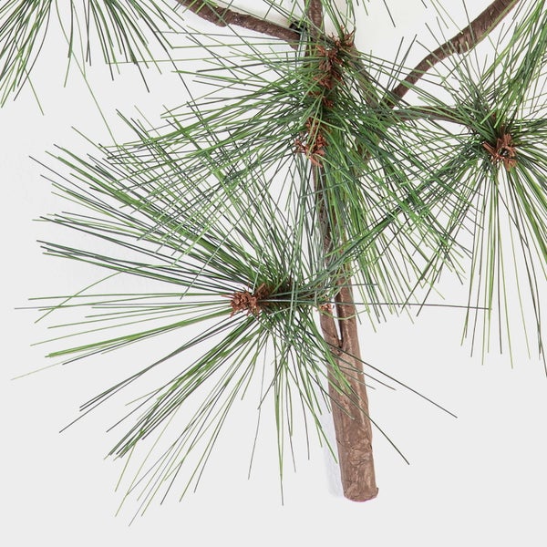 Nahaufnahme einer künstlichen Bambuspflanze mit grünen Blättern und braunen Stielen für die Innendekoration.