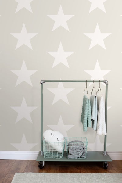 Kinderzimmer mit Sternentapete, Kleiderständer auf Rollen, Körben und Textilien