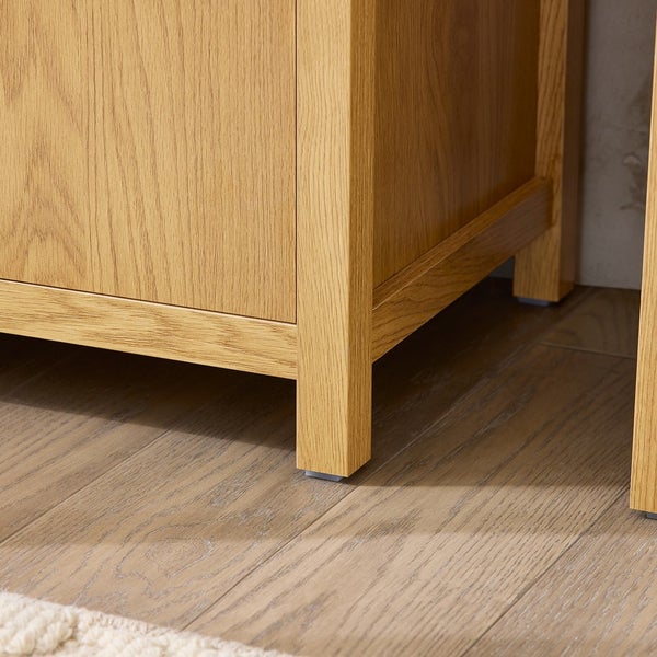 Detailaufnahme eines Holzschranks mit Füßen auf einem Holzboden