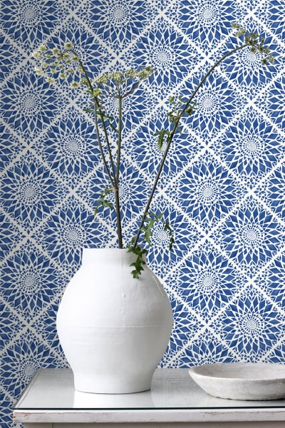 Dekorative Tapete mit geometrischem Muster, Vase mit Blumen auf einem Tisch