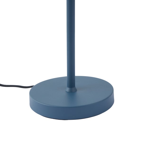 Runder Standfuß einer blauen Metallleuchte mit schwarzem Stromkabel.