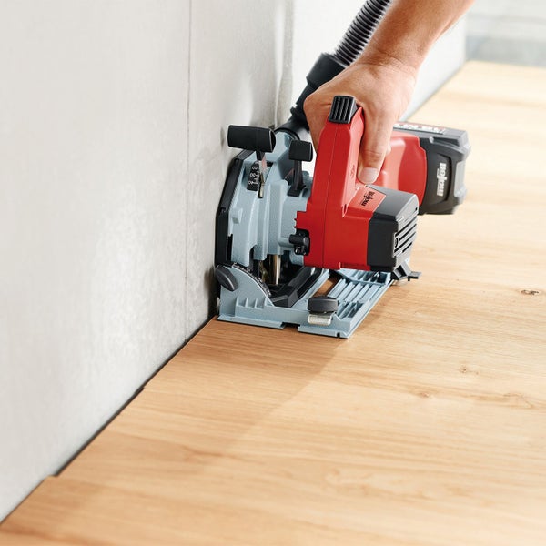 Handwerker nutzt eine Mafell Schattenfugenfräse für einen präzisen Schnitt in eine Holzplatte nah an einer Wand.