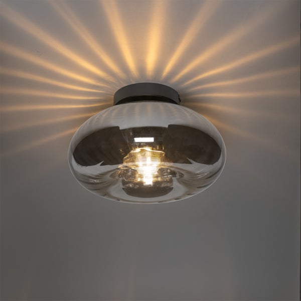 Deckenleuchte mit transparentem Glasschirm und eingeschalteter Glühbirne