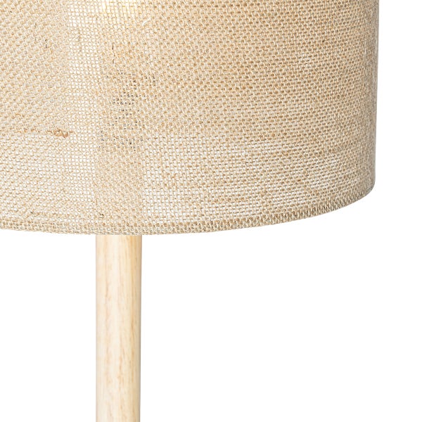 Lampenschirm aus strukturiertem Stoff auf einem Holzständer als Teil einer Stehlampe