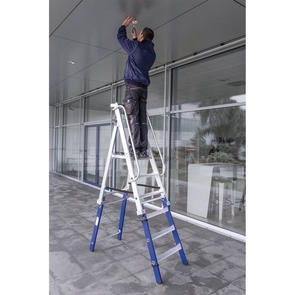 Mann montiert Leuchte von Stehleiter aus