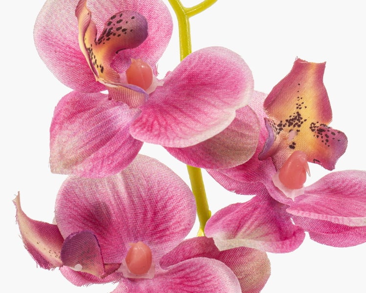 Künstliche Orchidee im Tontopf mit rosa Blüten und grünen Blättern