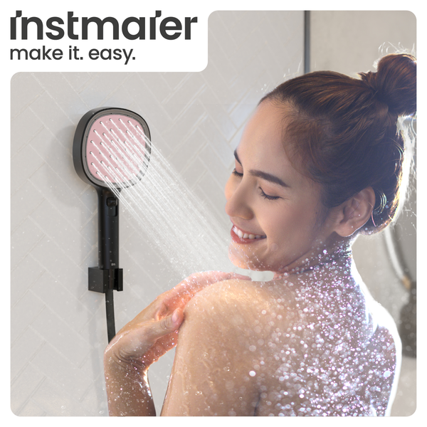 Eine Frau unter einer modernen Handbrause von Instmaier in einer hellen Dusche.