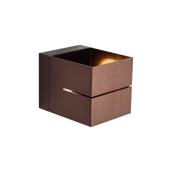 Würfelförmige Wandleuchte aus gebürstetem Metall in Bronzeoptik mit Lichtaustritt durch einen horizontalen Schlitz.