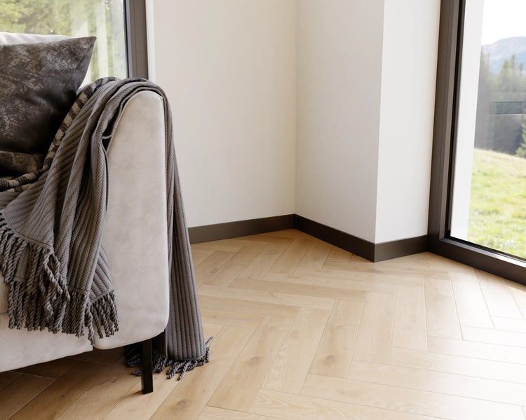 Innenraumansicht mit hellem Parkettboden im Fischgrätmuster und Sofa