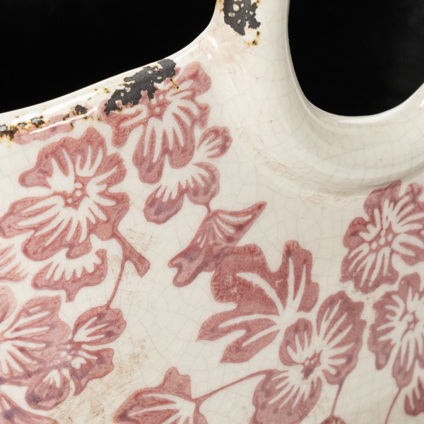 Nahaufnahme einer Keramikoberfläche mit Craquelé-Glasur und rosa Blumenmuster.