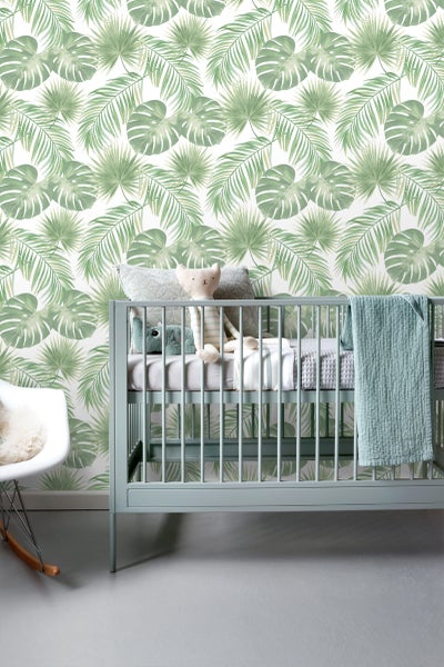Kinderzimmer mit botanischer Tapete, Kinderbett und Schaukelstuhl