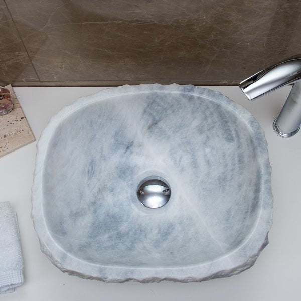 Aufsatzwaschbecken aus Naturstein mit Marmorierung und rauer Außenkante, inklusive verchromtem Ablauf und Armatur.