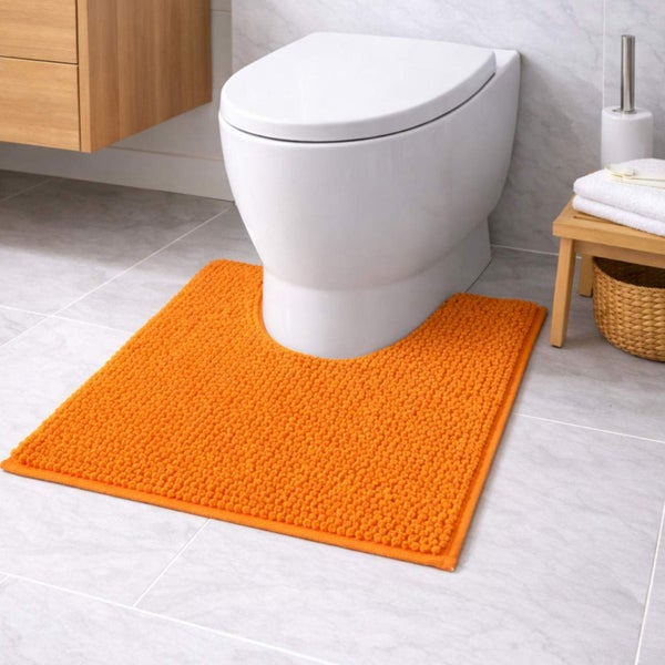 Oranger Toilettenvorleger mit Chenille-Struktur vor einer weißen Standtoilette in einem hell gefliesten Badezimmer.