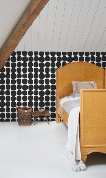 Schlafzimmer mit gemusterten Tapeten, Bett und dekorativen Accessoires