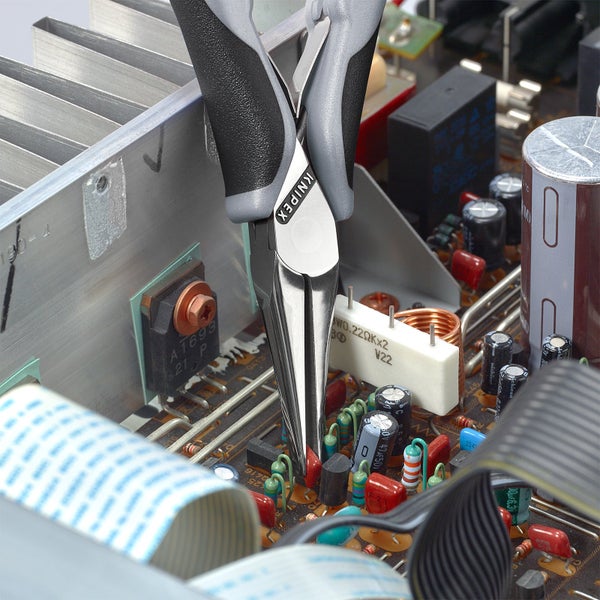 Knipex Elektronik-Seitenschneider im Einsatz auf einer Platine mit elektronischen Bauteilen.