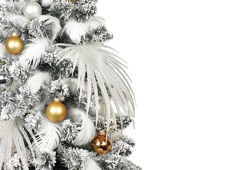 Künstlicher Weihnachtsbaum mit Schnee, Federn, glänzenden Kugeln und dekorativem Palmblatt als Baumschmuck für eine festliche Weihnachtsdekoration.