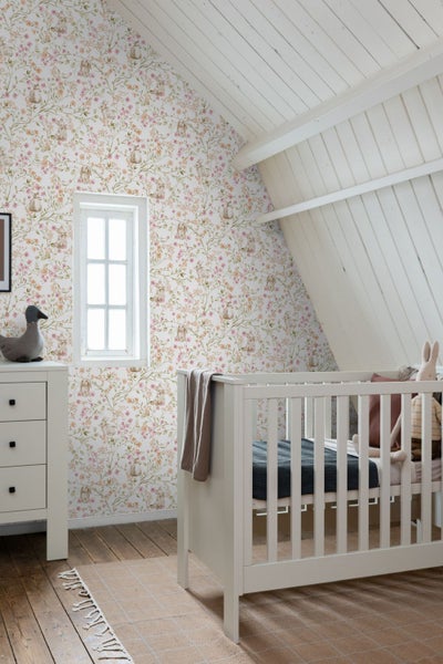 Babyzimmer mit floraler Tapete, Kinderbett und Kommode