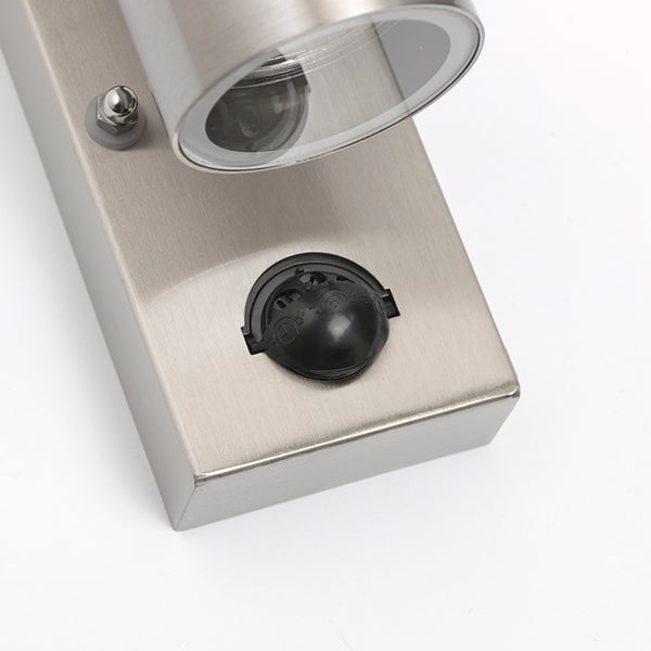 Detailaufnahme einer Außenwandleuchte aus gebürstetem Edelstahl mit einem Bewegungsmelder.