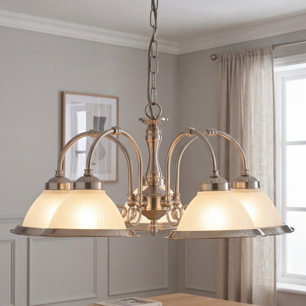 Klassischer Kronleuchter mit fünf Lichtquellen und gerippten Glasschirmen an einer Metallkette in einem eleganten Wohnzimmer.