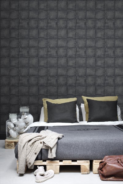 Schlafzimmer mit grauer Wandtapete im Fliesenlook, Bett auf Europaletten