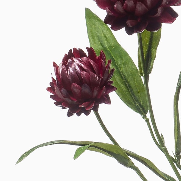 Künstlicher Blumenzweig mit dunkelroten Blüten und grünen Blättern.