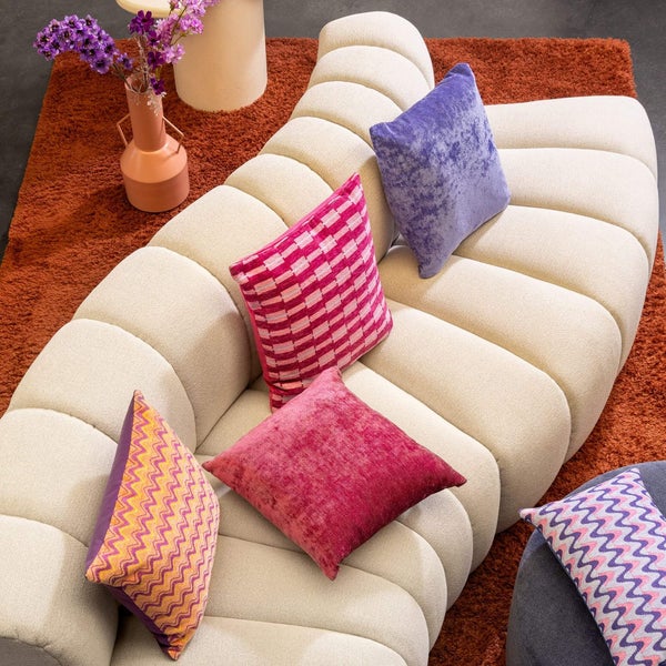 Ansicht von oben eines Sofas mit Kissen und Teppich