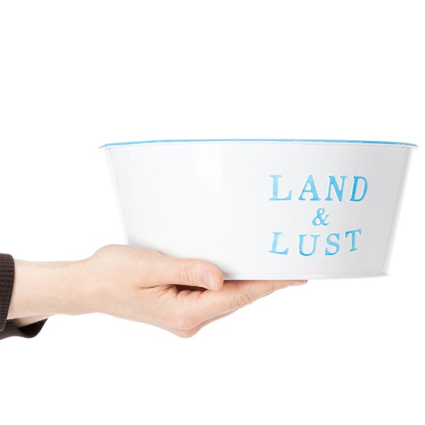 Weiße Metallschale mit blauem Rand und Aufschrift Land und Lust, in einer Hand gehalten zur Größendarstellung.