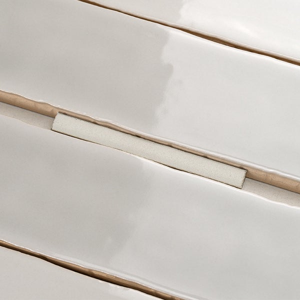 Wandfliesen mit glatter, glänzender Oberfläche in horizontaler Anordnung mit ausgeprägter Fugenstruktur.