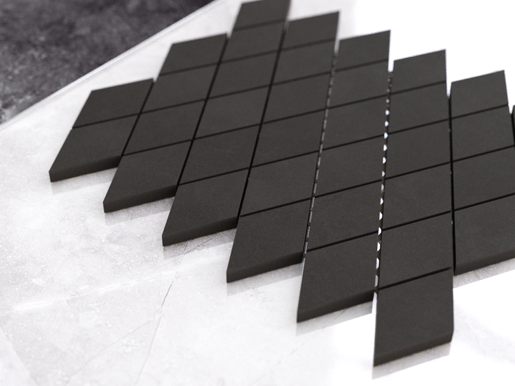 Dunkle matte Mosaikfliesen in Rautenform aus Feinsteinzeug.