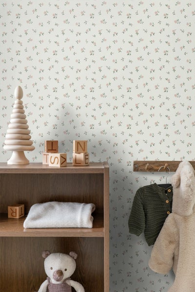 Tapete mit kleinem Blumenmuster in hellem Kinderzimmer mit Holzregal, Spielzeug und Kleiderhaken.