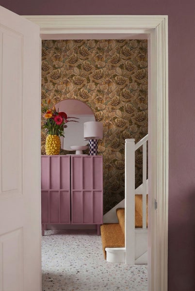 Flur mit floraler Tapete, Kommode, Spiegel und Treppe
