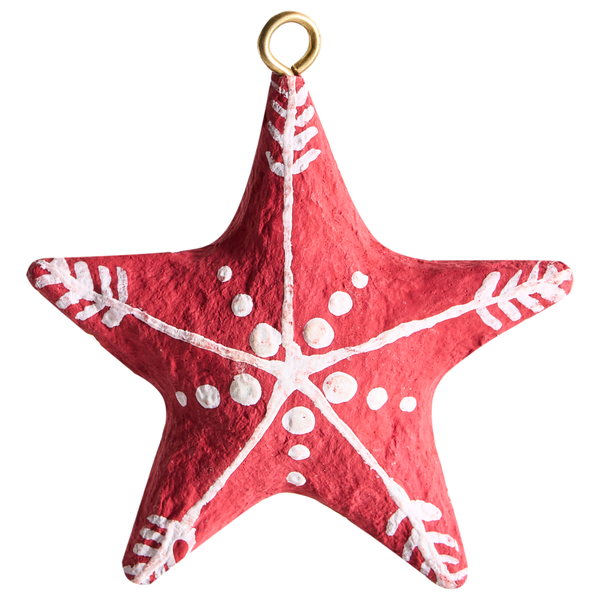 Roter Weihnachtsstern aus Pappmaché mit weißem Muster und goldener Aufhängeschleife.