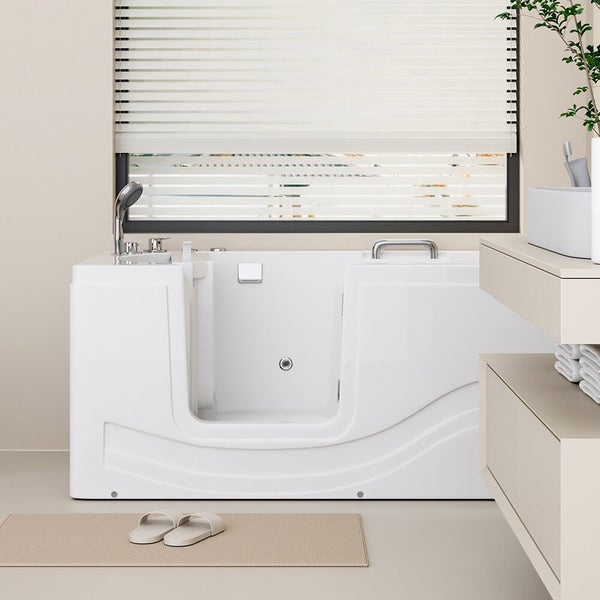 Seniorengerechte Badewanne mit Einstiegstür und Handbrause in einem hellen Badezimmer mit Waschtisch und Fenster.