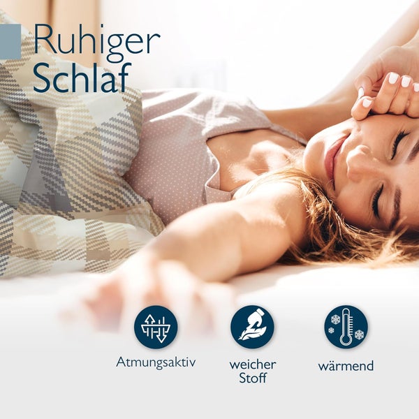 Schlafende Frau unter einer gemusterten Bettdecke mit den Eigenschaften atmungsaktiv, weicher Stoff und wärmend.