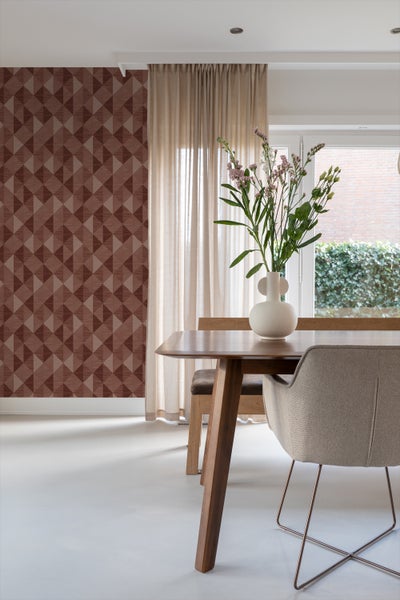 Esszimmer mit Esstisch, Stuhl, Vase mit Blumen und geometrischer Tapete