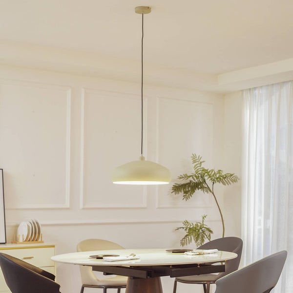 Moderne Pendelleuchte in einem hellen, organisierten Esszimmer über einem runden Esstisch mit Zimmerpflanze und Fenster im Hintergrund.