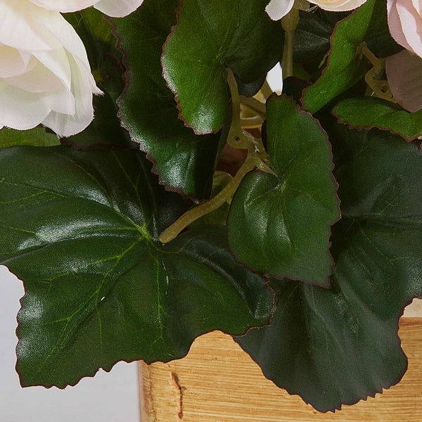 Künstliche Begonie in dekorativem Übertopf mit hellrosa Blüten und grünen Blättern.