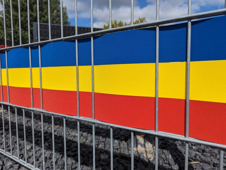 Metallzaun mit farbigen Streifen