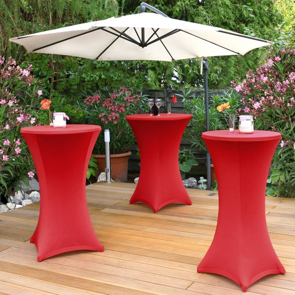 Drei rote Stehtische mit Hussen und Sonnenschirm im Garten.