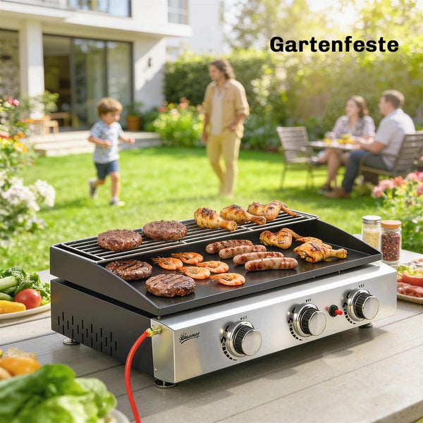 Tischgasgrill mit Grillgut wie Patties, Würstchen, Hähnchen und Garnelen im sonnigen Garten bei einer Feier.