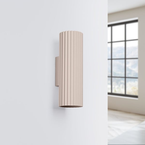Wandleuchte mit geriffeltem Schirm an einer weißen Wand