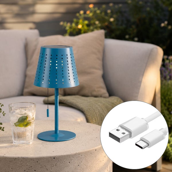 Dekorative Solar Tischleuchte für den Außenbereich mit USB C Ladekabel auf einem Beistelltisch vor einem Sofa im Garten.
