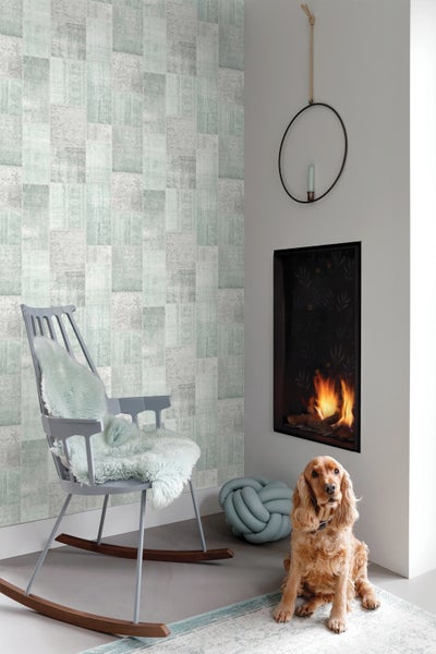 Wohnzimmer mit gemusterter Tapete, Kamin und Hund