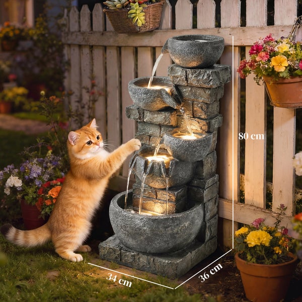 Kaskadenbrunnen in Steinoptik aus bemaltem Harz für den Garten, wetterfest nach Schutzart IP44, mit Blumen und Gartenfiguren dekoriert.